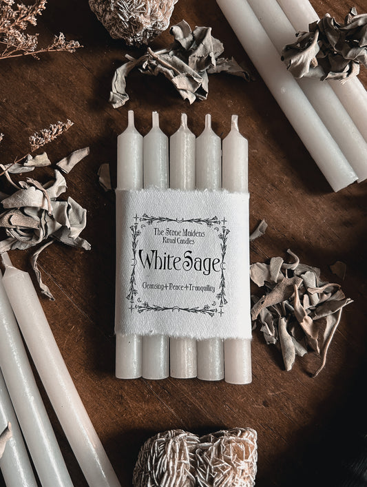 White Sage Ritual Candles arranged on a dark wooden altar surrounded by crystals, sold at The Stone Maidens