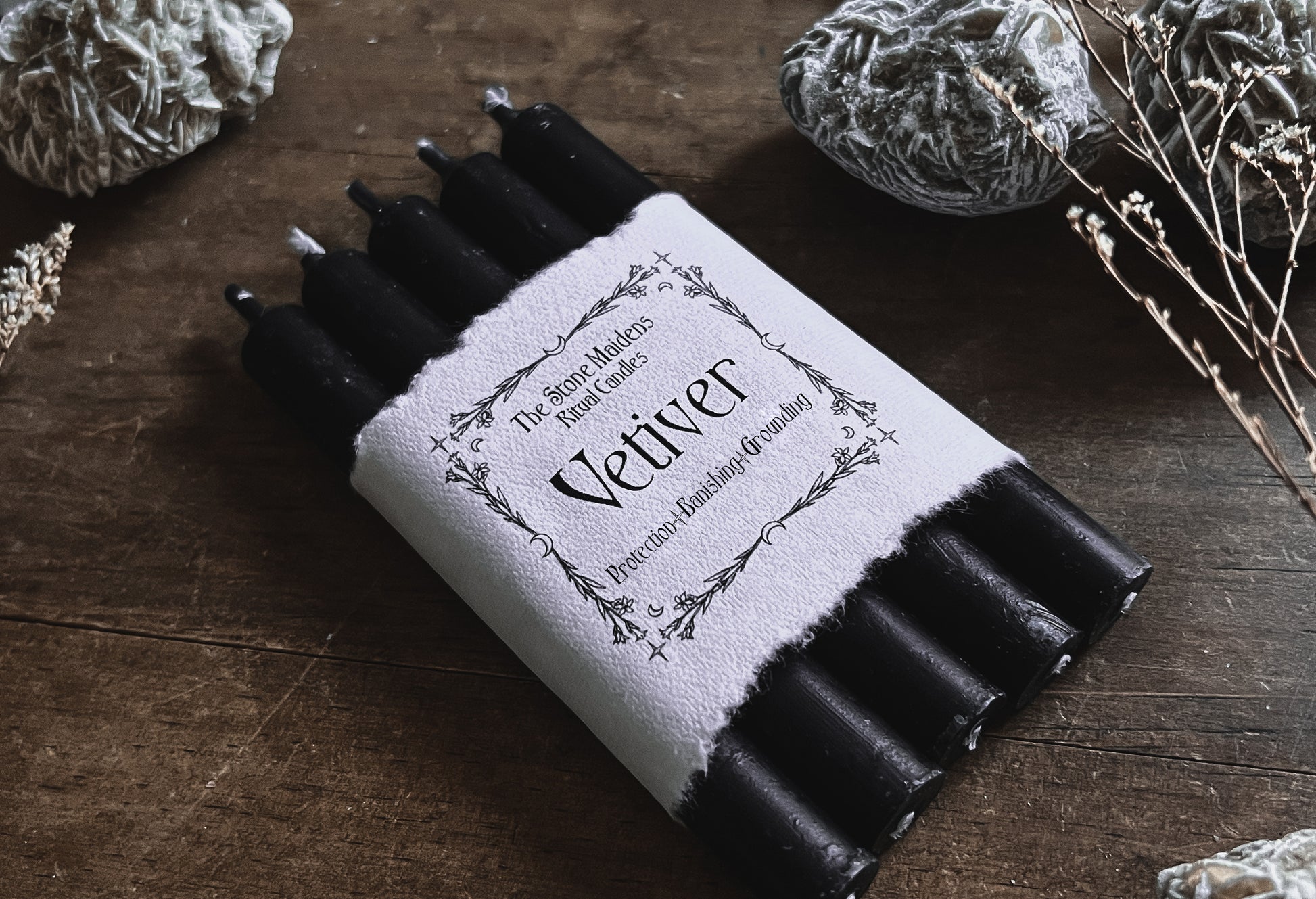 Vetiver Black ritual candles arranged on a dark wooden altar surrounded by crystals, sold at The Stone Maidens