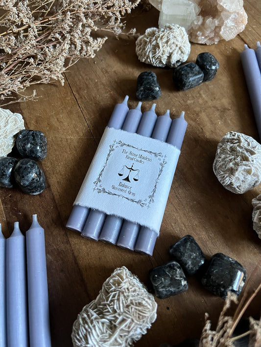 Gray Unscented ritual candles arranged on a dark wooden altar surrounded by crystals, sold at The Stone Maidens