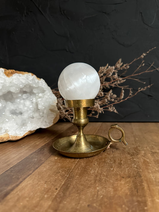 A vintage brass candle holder used as a selenite sphere holder. 