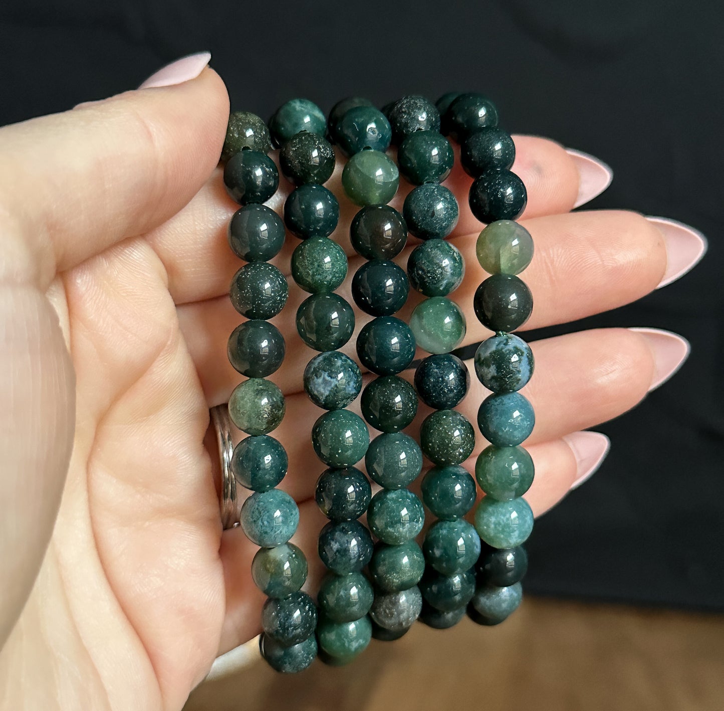 Close-up photograph of an 8mm Moss Agate Bracelet, showcasing its natural green hues and unique patterns