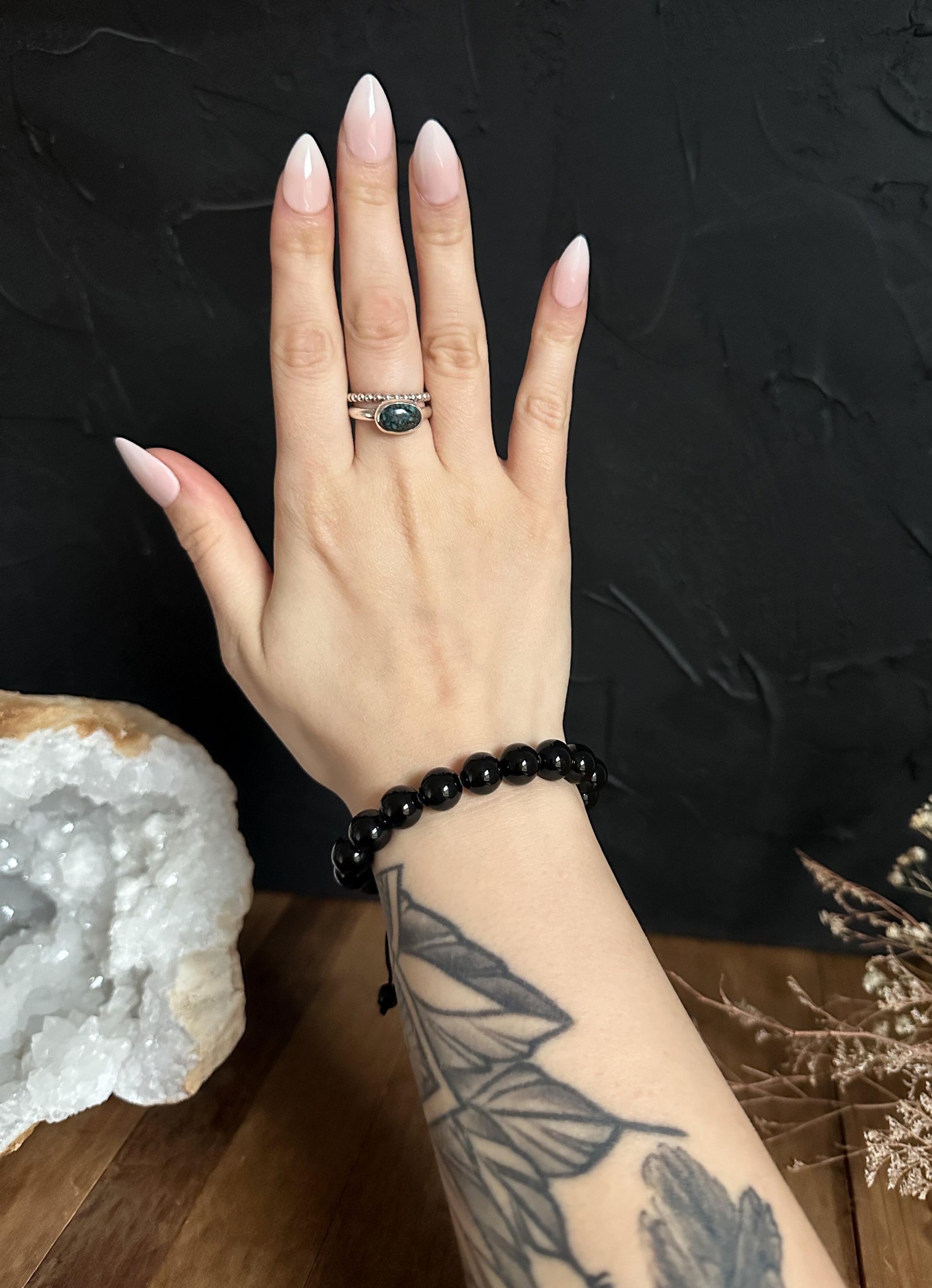 Close-up photograph of a 10mm Black Obsidian Bracelet, highlighting its sleek black surface and natural sheen. 