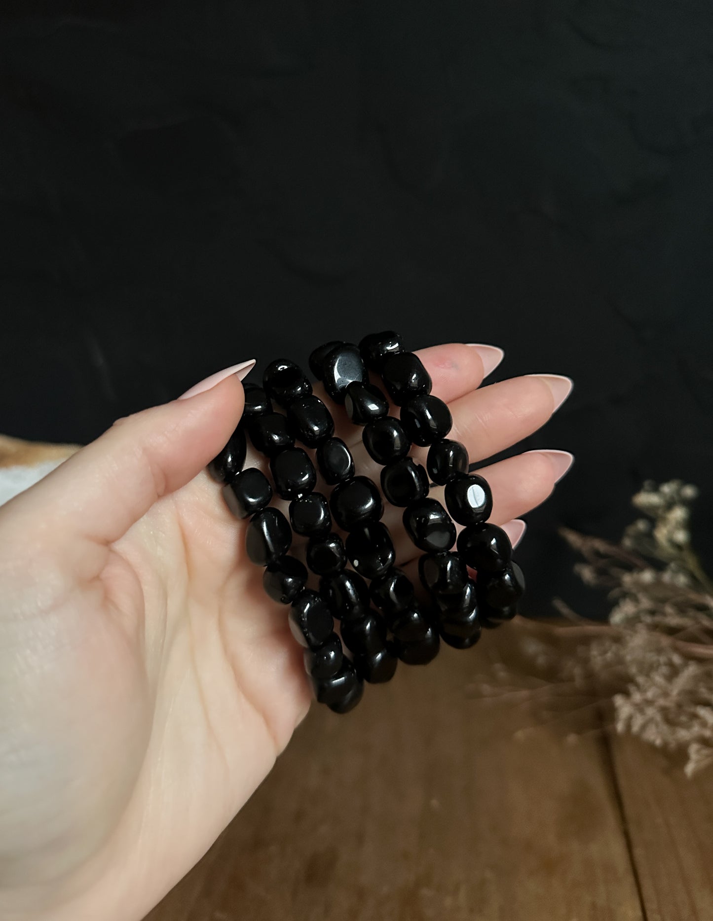 close up photograph of The Stone Maidens Obsidian Tumbled Nugget Bracelet . That is made up of 10mm to 12mm beads