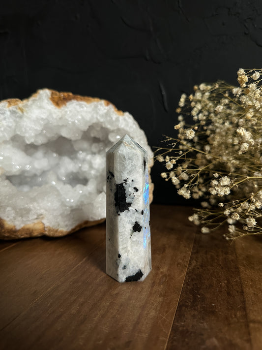 Shimmering moonstone tower with natural iridescence, standing tall and captivating. Perfect for crystal healing, meditation, and spiritual practices. Each facet reflects the ethereal beauty of the moon, enhancing intuition and emotional balance. Ideal for collectors and enthusiasts seeking unique gemstone specimens.