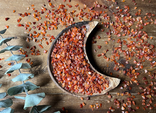 Carnelian Crystal Chips in a wood moon dish and scattered around.