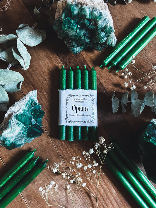 Opium Green ritual candles arranged on a dark wooden altar surrounded by crystals, sold at The Stone Maidens