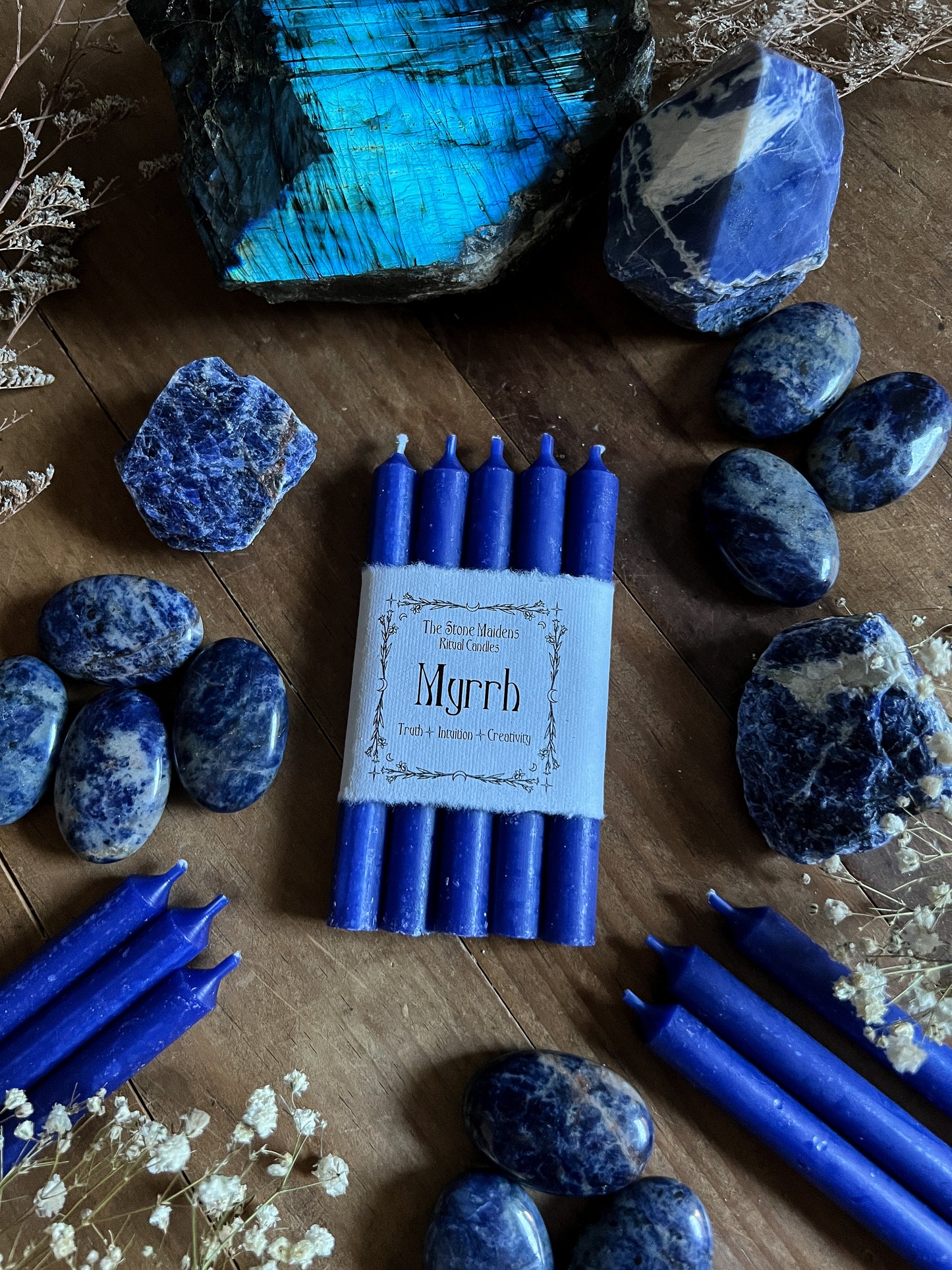 Blue Myrrh Chime candles arranged on a dark wooden altar surrounded by crystals, sold at The Stone Maidens
