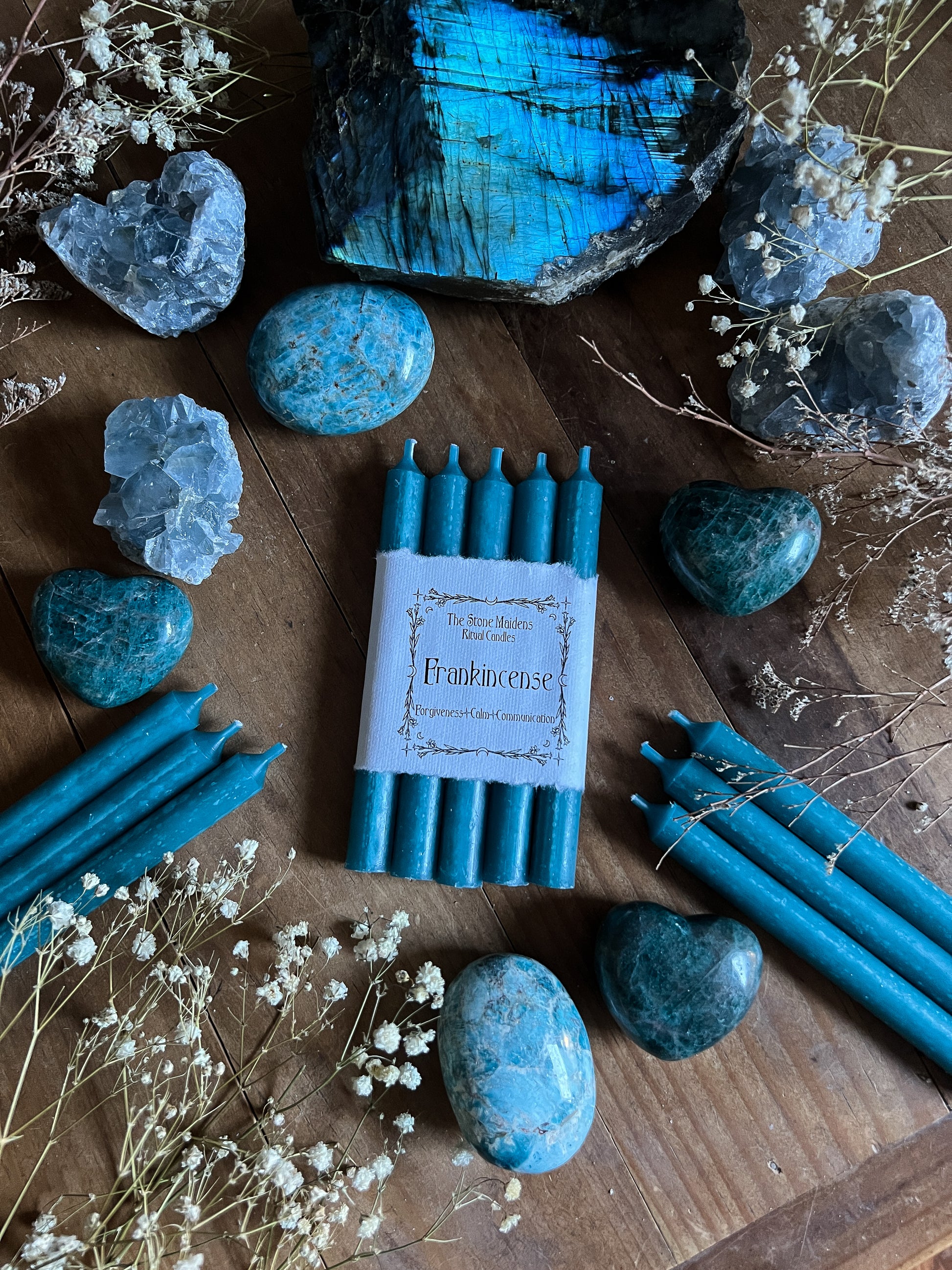 Frankincense ritual candles arranged on a dark wooden altar surrounded by crystals, sold at The Stone Maidens