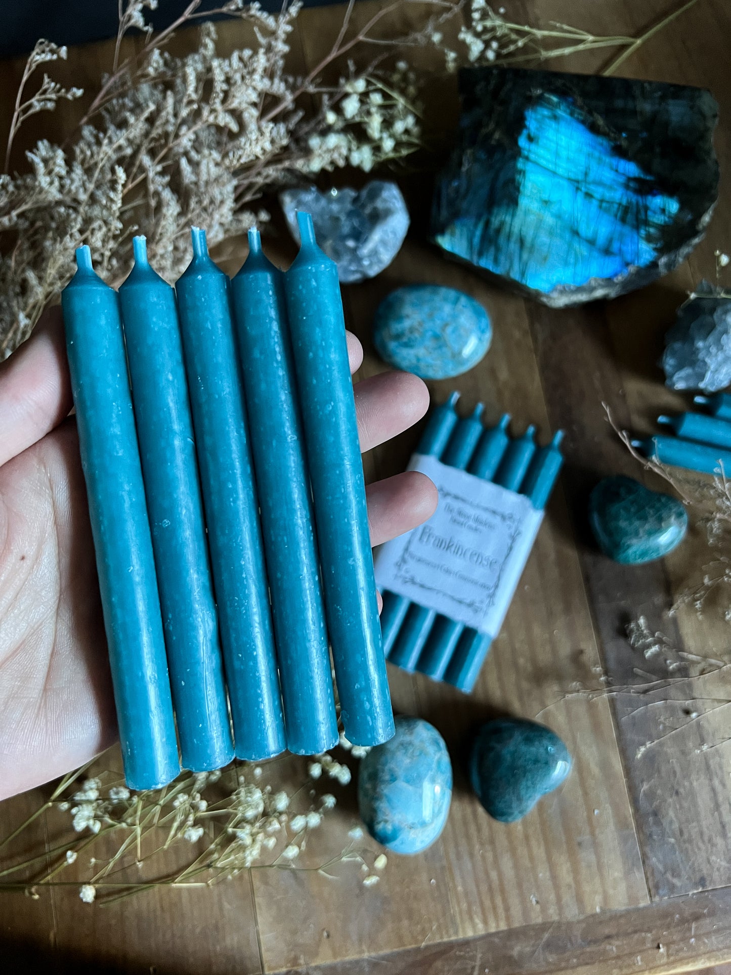 Light Blue ritual candles arranged on a dark wooden altar surrounded by crystals, sold at The Stone Maidens