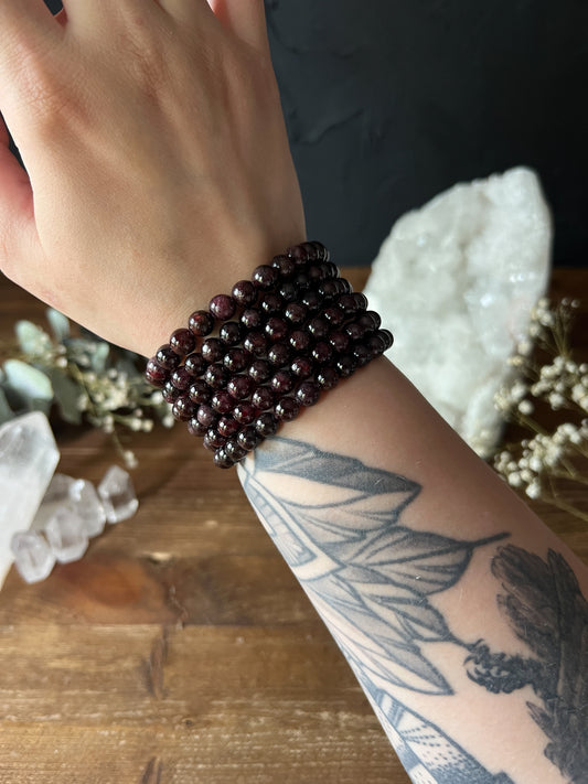7mm Garnet Bracelets stacked on a wrist.