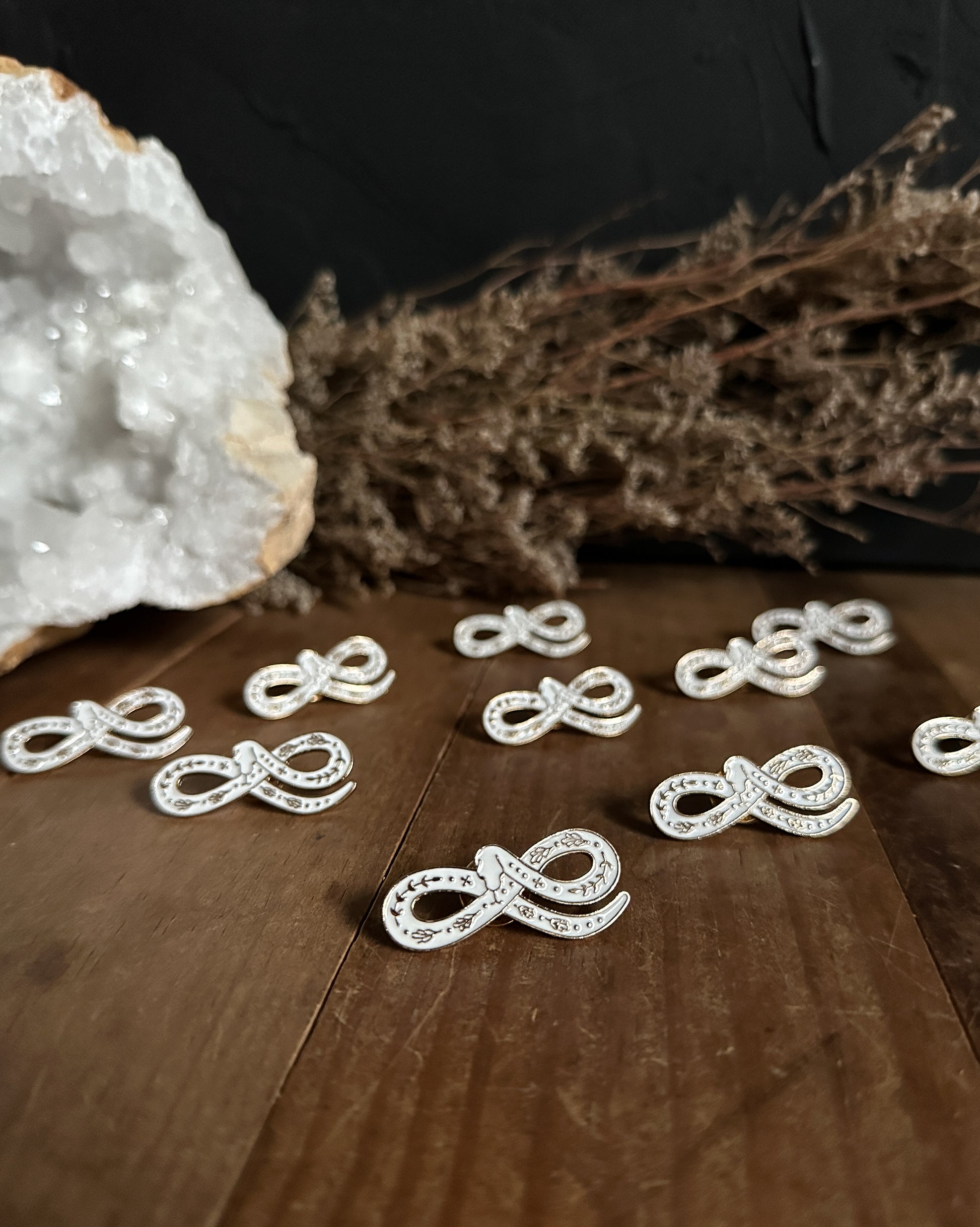 a group of White Snake Enamel Pins at the Stone Maidens
