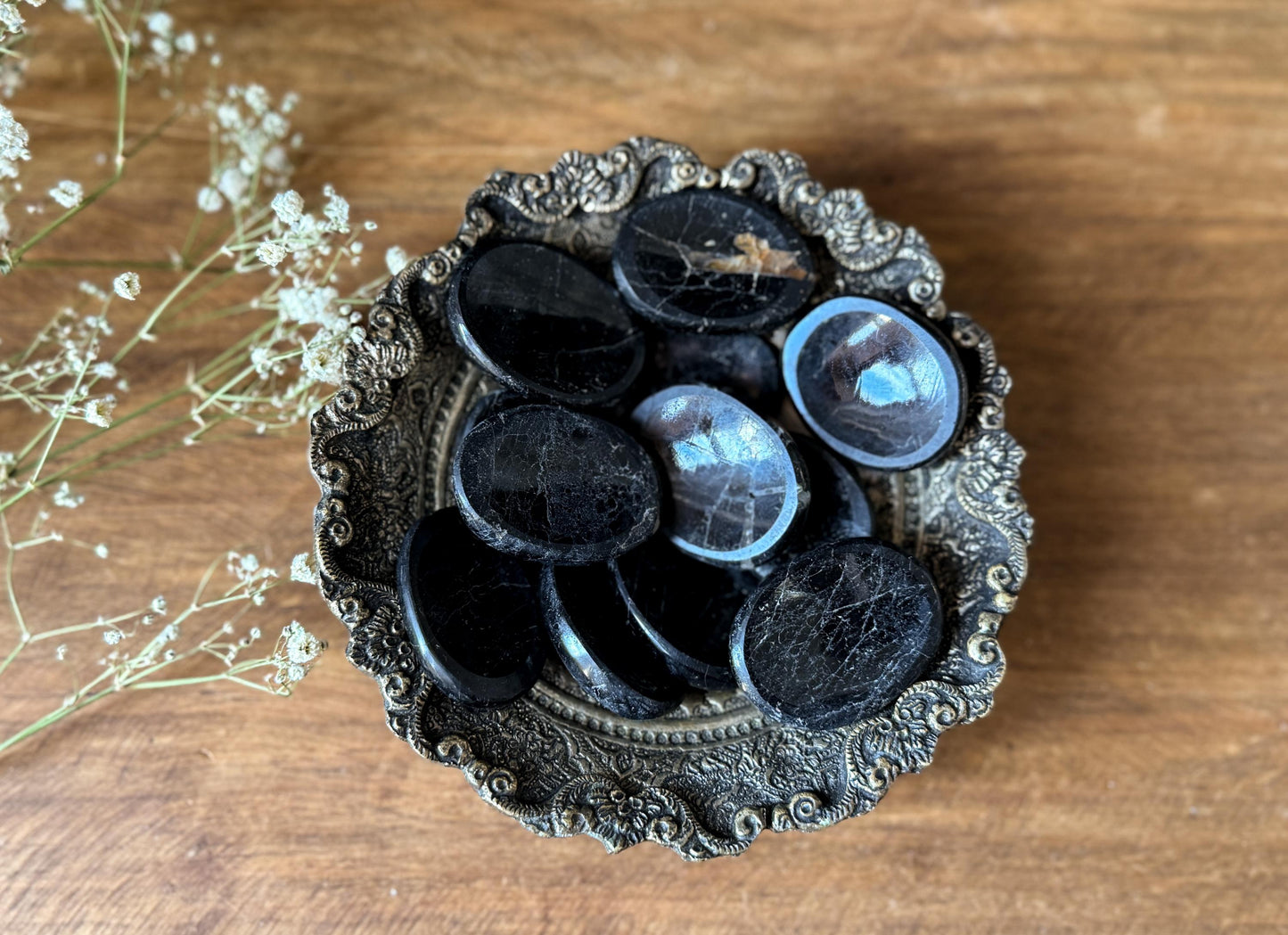 Black Tourmaline Worry Stones in an antique brass bowl at The Stone Maidens