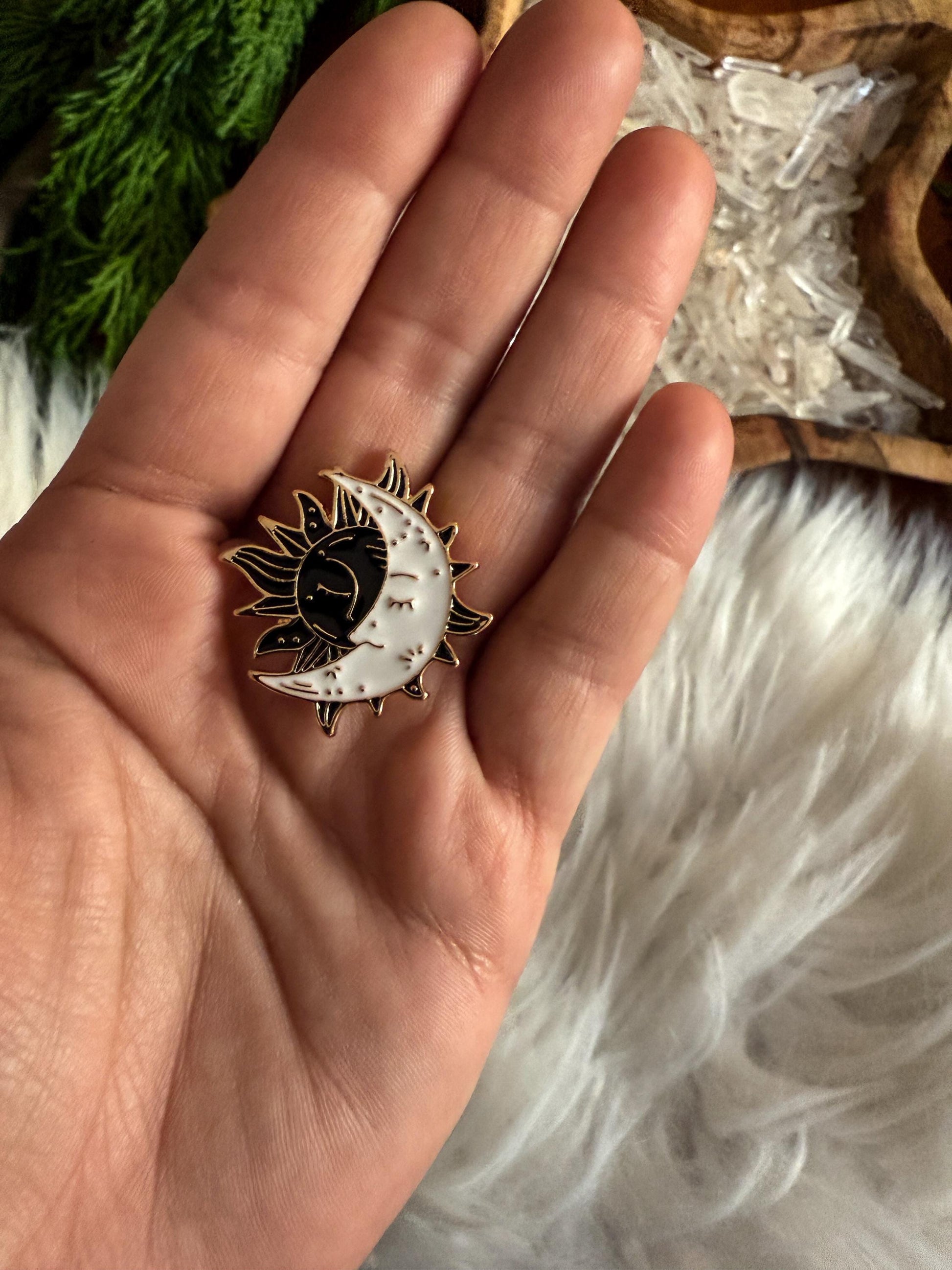 Black Sun and White Moon Enamel Pin in the hand of The Stone Maidens 