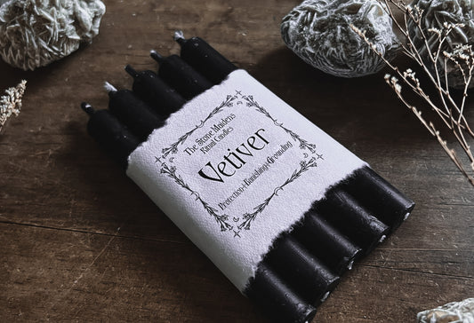 Vetiver Black ritual candles arranged on a dark wooden altar surrounded by crystals, sold at The Stone Maidens