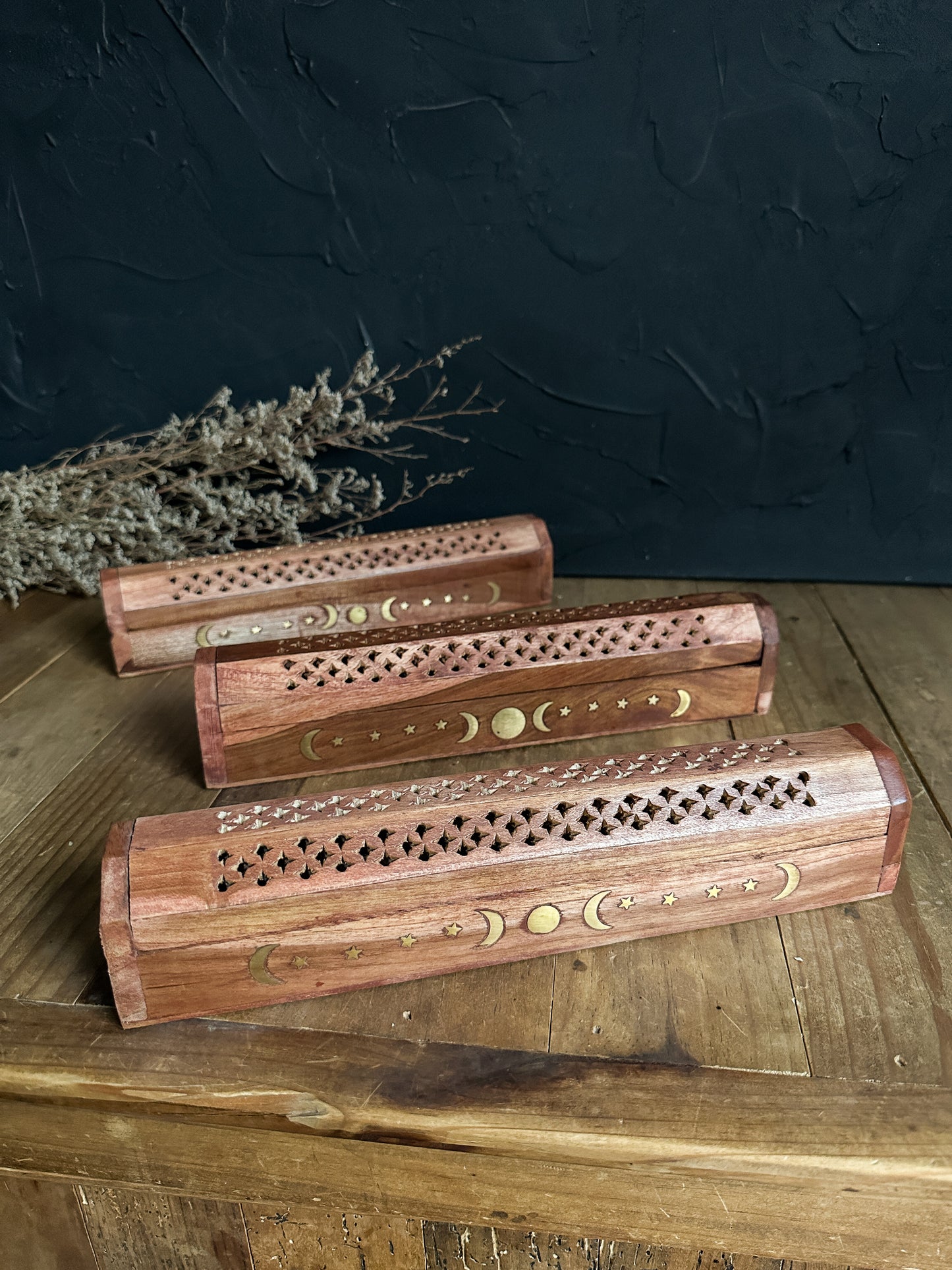 Wood incense burner storage box featuring brass moon and star inlays on the lid, perfect for safely storing incense sticks and cones. Sold at The Stone Maidens