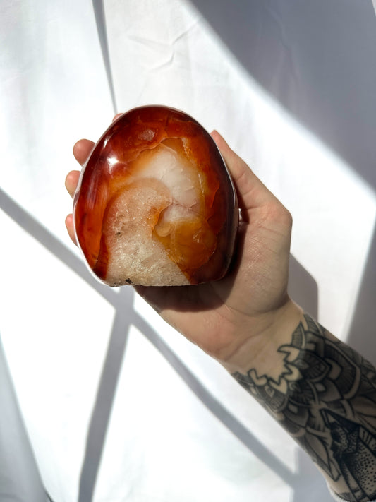 mesmerizing Carnelian Freeform is adorned with dark red and orange hues complemented by hints of quartz