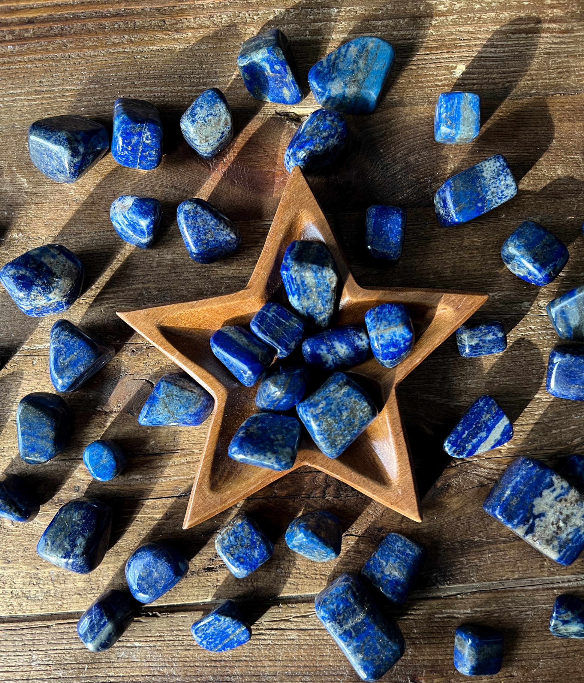 Lapis Lazuli Tumbled Stones in a wood star dish at The Stone Maidens 