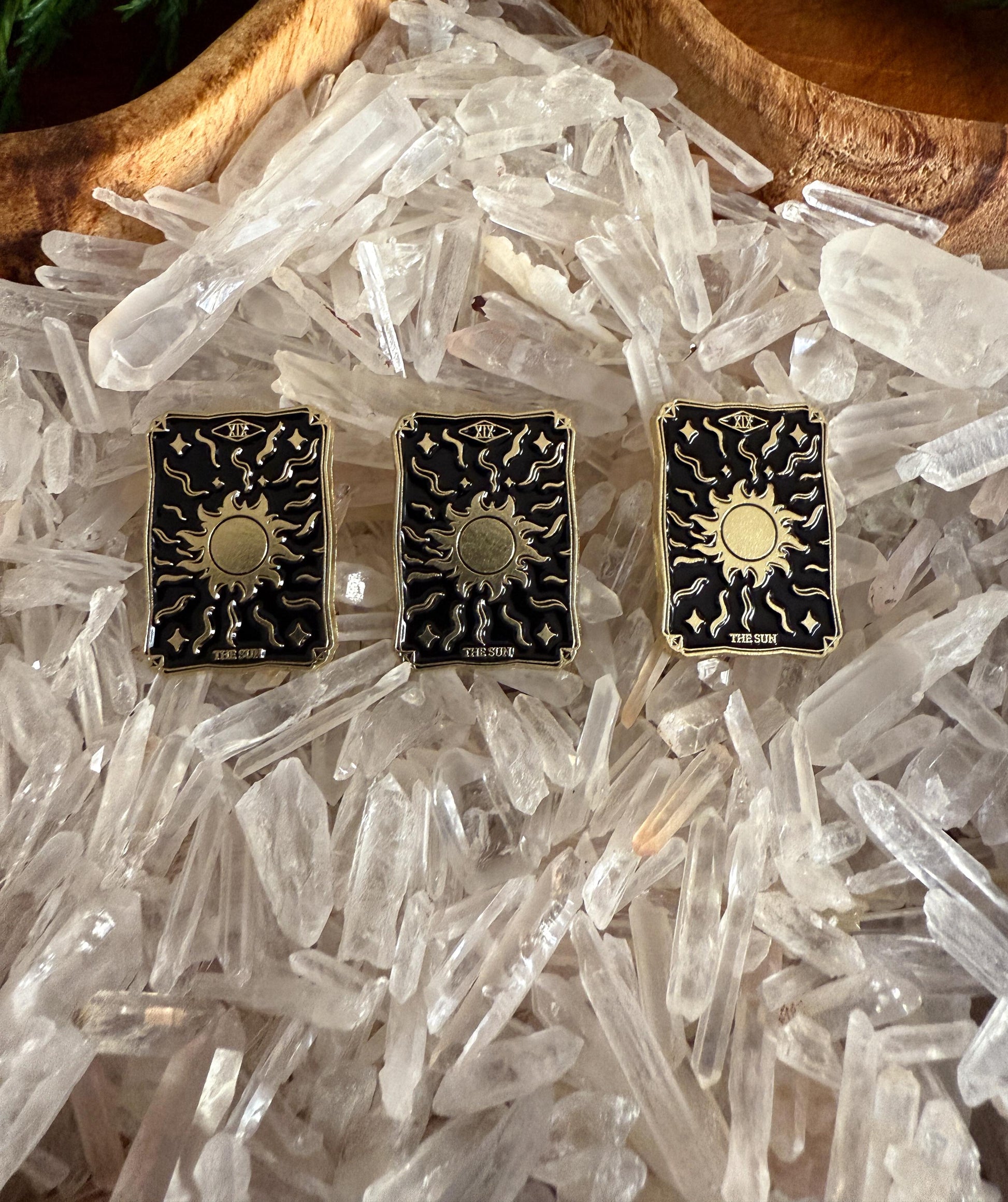 The Sun Tarot Card Enamel Pins on a bed of Crystal Quartz Pioints